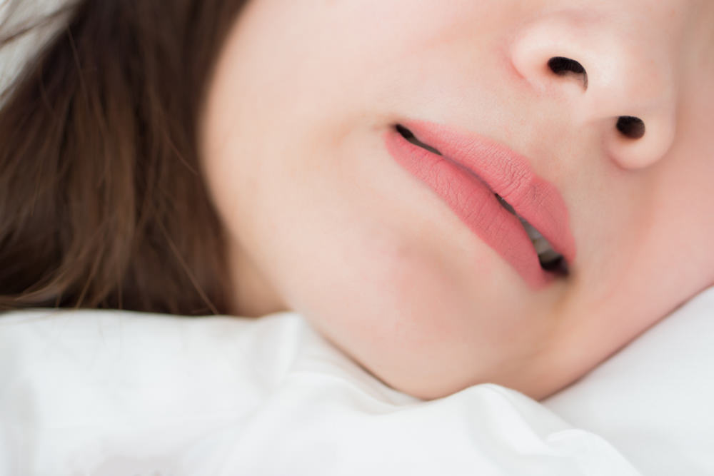 A woman sleeping with an partial open mouth