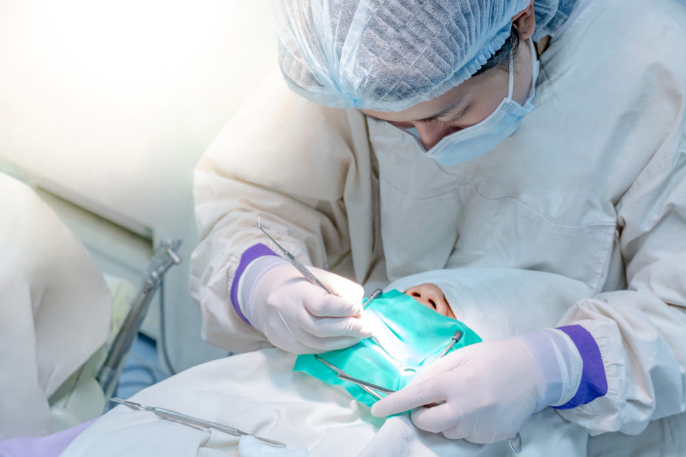 A dentist working on a patient with a dental dam