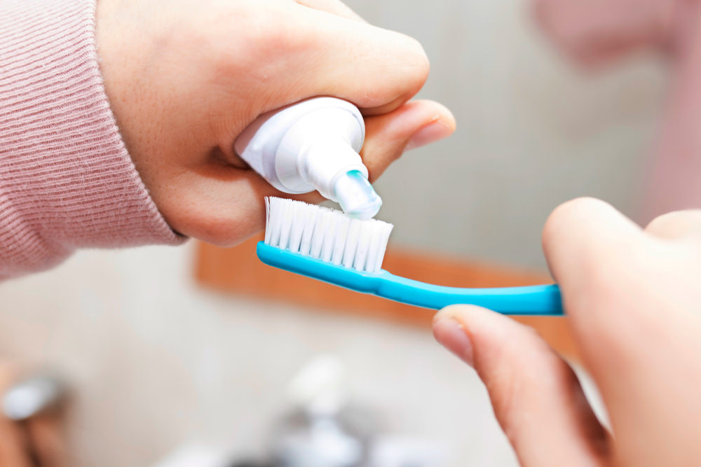 putting toothpaste on their brush