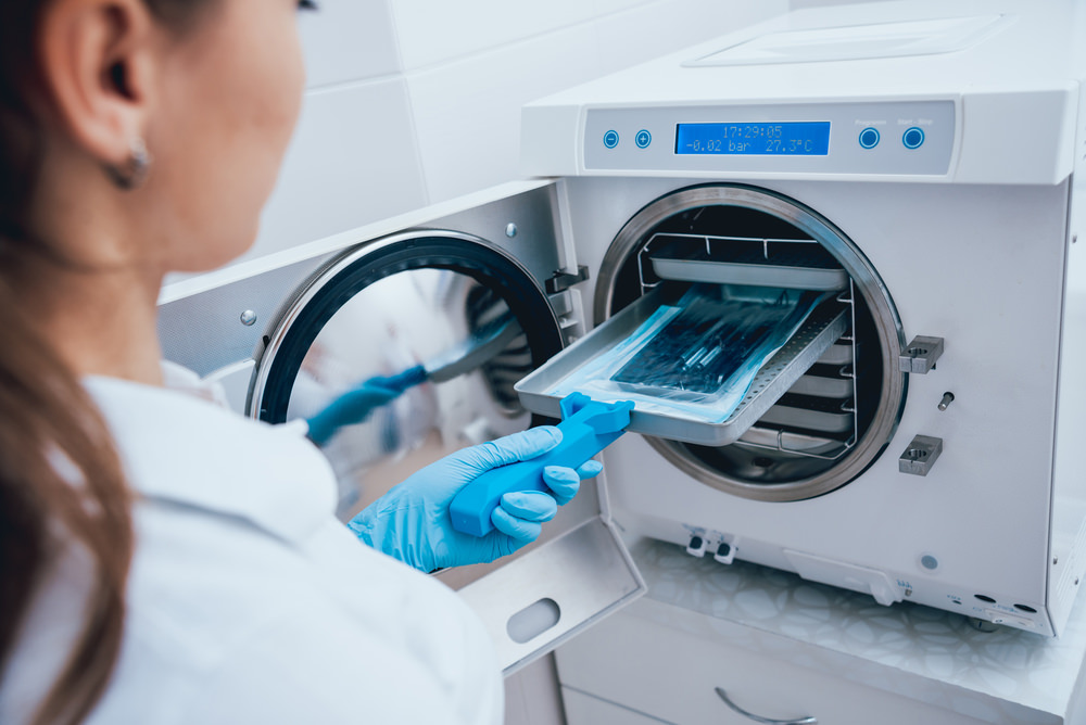 A dental assistant sterilising dental instruments